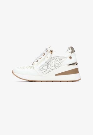 Zapatilla blanca con detalles perforados, acentos metálicos y tacón cuña. Cuenta con cremallera lateral y cierre de cordones para ajustar.
