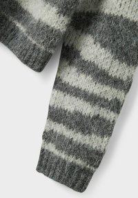 Pilko ir balto dryžuoto rašto megztos megztinio rankovės, turinčios minkštą, pūkuotą tekstūrą ir ribotą rankogalių detalę.