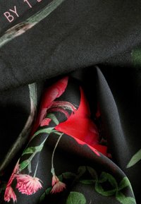 Floral patterned fabric with black background, featuring prominent red and pink flowers with green leaves, soft texture, and smooth finish.