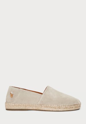 Beige suède espadrille met een jute touwzool, voorzien van een gestructureerde afwerking en een klein geborduurd logo op de hak.