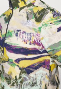 Fleece-pullover i flerfärgad abstrakt mönster med nyanser av gult, grönt och lila. Inkluderar kvarttsdragkedja och logotyp på bröstet.