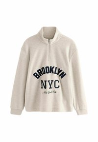 Beige kvart-zip sweatshirt med "BROOKLYN NYC" tekst i marineblå og "New York City" i kursiv. Blød, fleece-lignende tekstur, afslappet pasform.