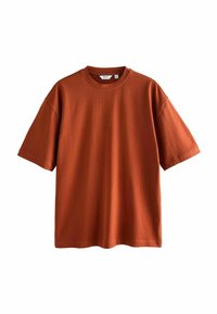 Camiseta de manga corta de color óxido con cuello redondo, hecha de tejido suave, que presenta un corte relajado y detalles de costura mínimos.