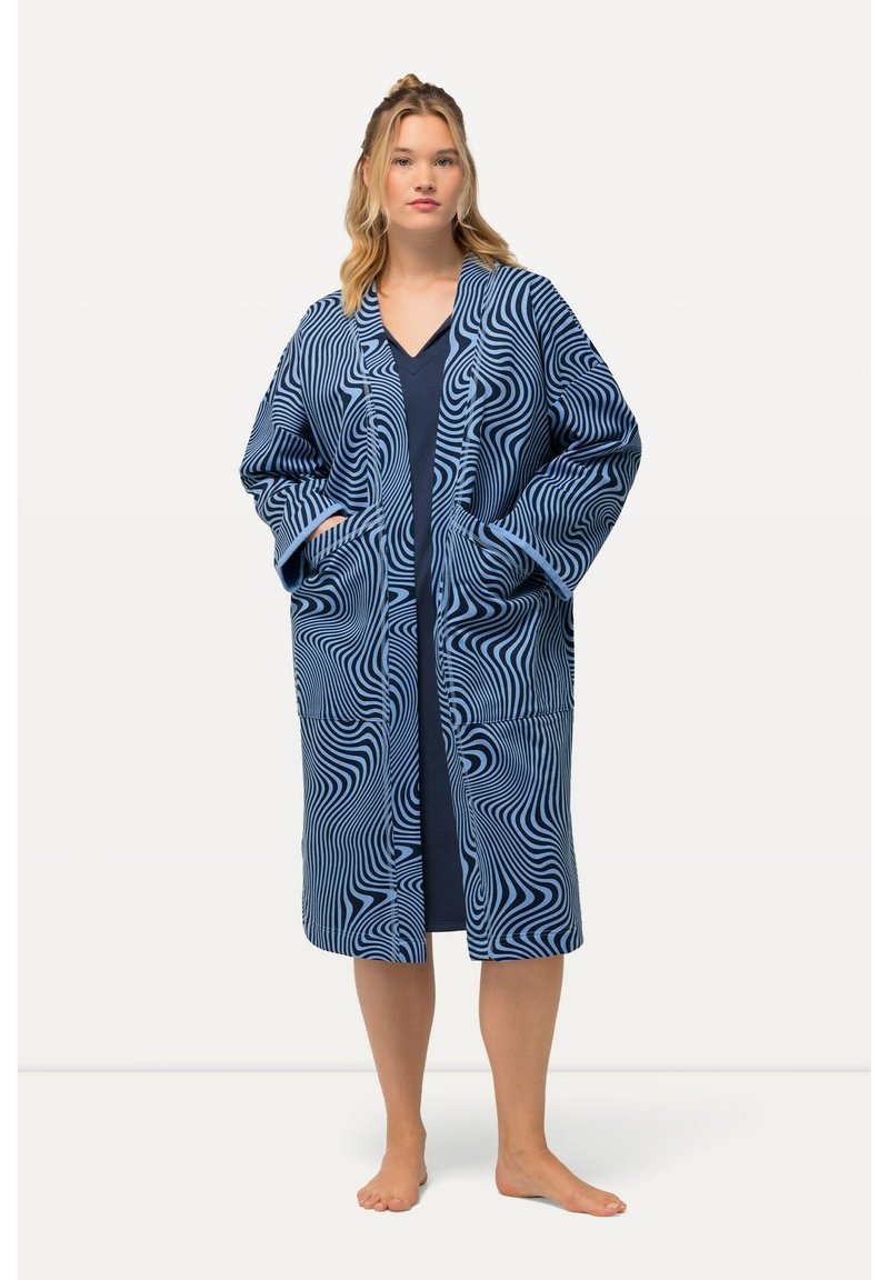 Blå mönstrad badrock med vågiga mönster. Har vida ärmar, fickor och en lös passform, bärs över en marinblå klänning. Ljuvlig textur.