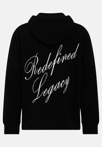 Μαύρη κουκούλα φούτερ με απαλή υφή. "Redefined Legacy" τυπωμένο σε λευκή καλλιγραφία στην πλάτη. Κλασική γραμμή με ριμπ ύφανση στους καρπούς.