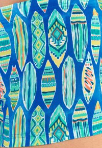 Badehosen mit einem blauen Hintergrund, geschmückt mit verschiedenen Surfbrettformen in Grün, Gelb und Orange, die geometrische Muster aufweisen.