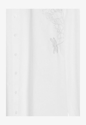 Valkoinen napitettava paita, jossa on perhosen siiven brodeeraus ja koristeompeleita, valmistettu kevyestä kankaasta, jossa on sileä pinta.