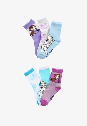 Six chaussettes colorées pour enfants représentant des personnages et le texte "Magic Winter" tirés d'un film d'animation populaire, disposées en deux groupes sur fond blanc.