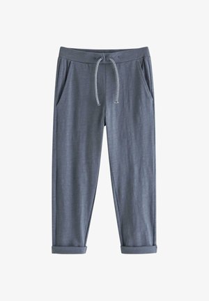 Grå afslappede bukser med snøre i taljen, sidelommer og op rullede kanter, lagt fladt på en hvid baggrund.