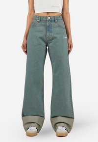 Ljusblå vida jeans med hög midja, med en urtvättad textur, framfickor och broderad logodetalj vid höften.