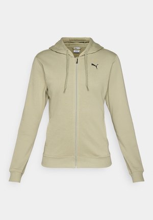 Haut à fermeture éclair vert olive clair en tissu doux, avec une poche kangourou, des poignets côtelés et un logo Puma noir sur la poitrine.