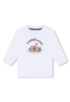 Witte langliggende T-shirt met lange mouwen, voorzien van een grafische print met "TIMBERLAND", een kampeerscène en kleurrijke cartoon elementen. Drukknopen op de schouder.