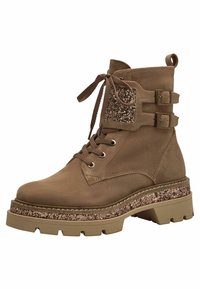 Bottine en daim brun avec fermeture à lacets, deux boucles réglables et un panneau d'accent pailleté. Semelle plateforme épaisse avec une finition texturée.