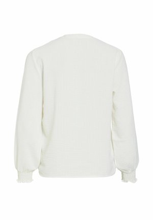 Bílá texturovaná halenka s dlouhým rukávem, elastickými manžetami a mírně volným střihem, zobrazena zezadu na jednobarevném pozadí.