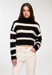 Czarny i biały paskowany krótki sweter z wysokim dekoltem i szerokimi rękawami, wykonany z miękkiego, teksturowanego materiału.