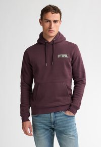 Pullover-Hoodie in dunklem Burgunderrot, aus weichem Material mit einer Fronttasche. Mit einem grauen Logo auf der Brust und verstellbaren Kordeln.
