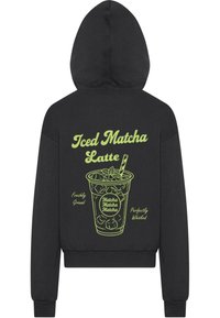 Felpa nera con cappuccio che presenta una grafica verde di un matcha latte ghiacciato, con il testo "Iced Matcha Latte", "Freshly Ground" e "Perfectly Whisked".