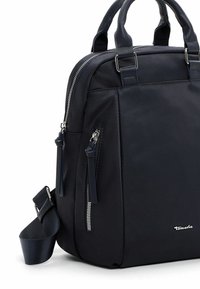 Sac à main noir de taille moyenne avec doubles poignées, poche zippée à l'avant, fermeture éclair et bandoulière réglable.
