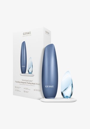 Blauwe en transparante langwerpige huidverzorgingsapparaten op een witte standaard, naast een witte doos met het label "GESKE Touchless Magnetic Peeling Mask 5 in 1."