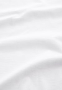 Tissu blanc lisse avec des plis doux créant des ombres délicates et une texture subtile sur toute la surface.