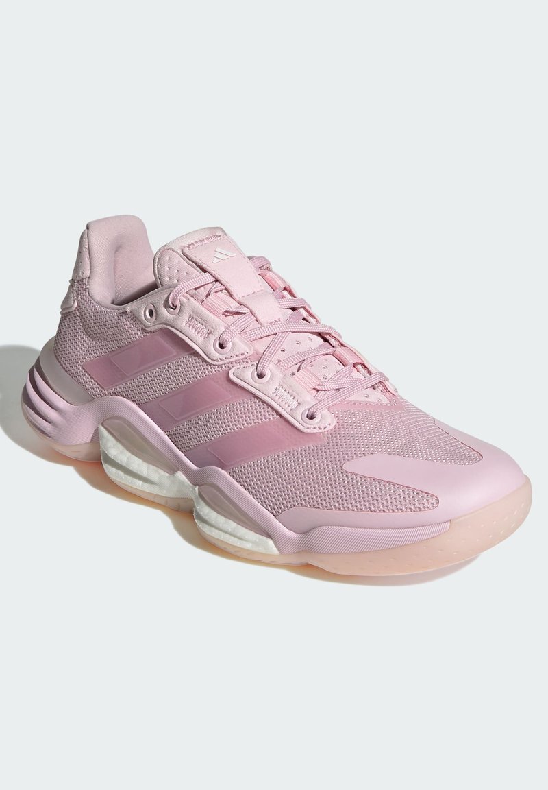 Zapatilla deportiva de color rosa claro con parte superior de malla, tres acentos de rayas, collar acolchado y suela gruesa y translúcida para mayor amortiguación.