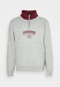Szary polarowy sweatshirt z bordowym wysokim kołnierzem, pół zamkiem błyskawicznym i logo w kolorze burgundowym z przodu. Posiada kieszeń z przodu.