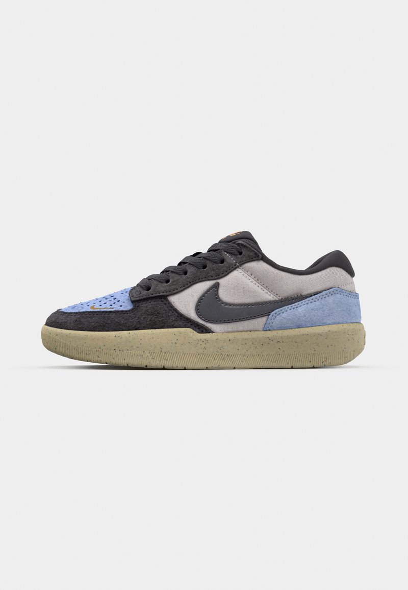 Sneakers Nike z mixem materiałów: czarny, szary i niebieski zamsz oraz tkanina z plamkowaną beżową podeszwą i wyraźnym czarnym logo.
