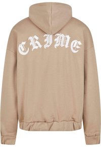 Sweat-shirt beige à capuche arborant un grand texte blanc "CRIME" dans une police stylisée au dos. Tissu doux avec des poignets et un ourlet côtelés.