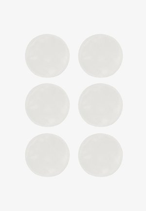 Valkoiset pyöreät puuvillapadat on järjestetty kahteen riviin, joissa on kolme padjaa, sileällä pinnalla ja ommelluilla reunoilla.