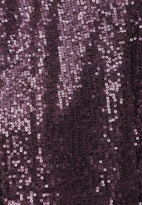 Tecido lilás com paetês, apresentando uma superfície texturizada, com pequenos paetês redondos distribuídos de forma uniforme, criando um efeito cintilante.