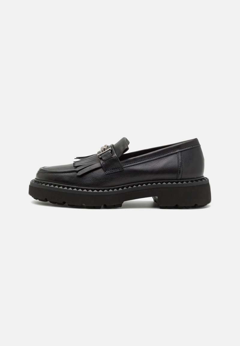 Mocassin en cuir noir avec semelle crantée épaisse, détail de pampille à franges et boucle argentée sur le côté, vu de profil extérieur.