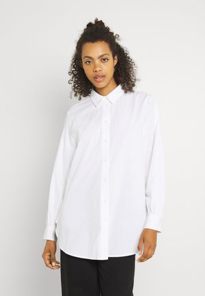 Camicia bianca a bottone con colletto, maniche lunghe e vestibilità rilassata. Realizzata in un tessuto liscio con una leggera texture. Caratteristiche di design classico.