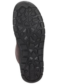 Suela de zapato de goma negra con un patrón de agarre texturizado que presenta formas angulares y crestas para una mejor tracción. Acentuada por un borde suave.