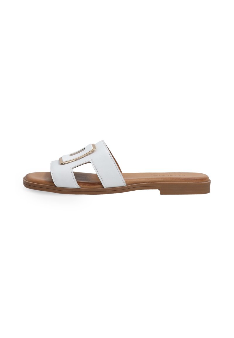 Witte leren sleehak sandaal met twee uitgesneden riemen en een rechthoekige gouden accent. Bruine zool, vlak ontwerp, minimalistische stijl.