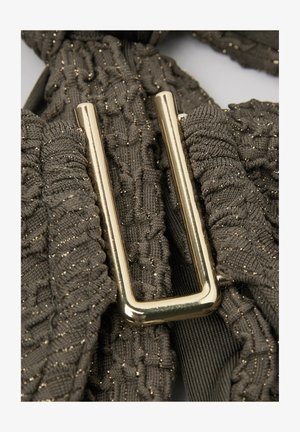 Hebilla rectangular dorada sobre tela texturizada gris oscuro con hilo metálico, mostrando detalles de punto fruncido y acanalado.