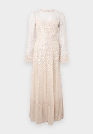 Vestido longo, bege, com mangas longas transparentes, adornado com pontos prateados espalhados, um corpete ajustado e uma saia fluida.