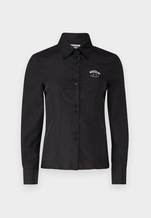 Black shirt with a fitted design, long sleeves, and a pointed collar. Features button front and embroidered logo on the chest.