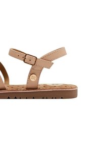 Sandalias de cuero marrón con dos correas finas y hebilla. Plantilla texturizada con un patrón de estrellas. Suela de goma gruesa con dibujo en zigzag.