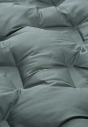 Umplutură matlasată dintr-un material teal estompat, având o textură netedă cu cusături vizibile și secțiuni ridicate, oferind un aspect căptușit.