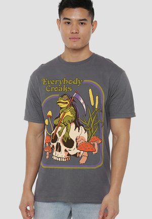 Man wearing a gray shirt with a frog holding a scythe, sitting on a skull surrounded by mushrooms and cattails, text "Everybody Croaks."
