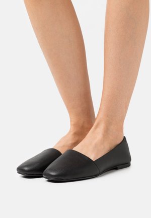 Zwarte platte schoenen van gestreept leer, met een ronde neus en een minimalistisch ontwerp, een lage hak en gladde zijkanten.