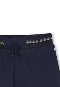 Marineblauwe joggingsbroek met een geribde tailleband met contrasterende gouden en zilveren accenten, een trekkoord en een soepele textuur.