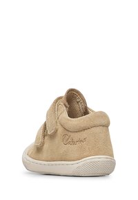 Béžová nubuková bota s kulatou špičkou, suchým zipem a strukturovanou gumovou podrážkou. Logo embossované na boku. Hladká vnitřní podšívka.