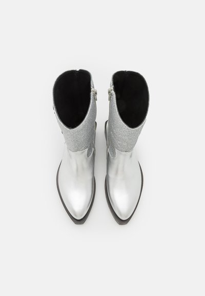Bottes cheville en argent avec une finition métallique et un revers en tissu gris texturé, dotées d'un bout pointu et d'un petit talon bloc.