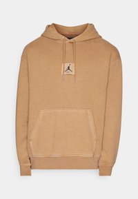 Felpa con cappuccio marrone realizzata in tessuto morbido, con tasca frontale, coulisse e una toppa con logo e silhouette sul petto.