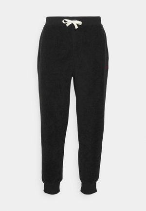 Zwarte fleece joggingbroek met een elastische tailleband, crèmekleurige trekkoord, zijzakken en geribbelde boorden. Klein rood logo op de linker heup.