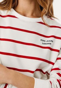 Sudadera blanca con rayas horizontales rojas, cuello acanalado y logo bordado "PEPE JEANS LONDON" en azul oscuro. Textura suave.