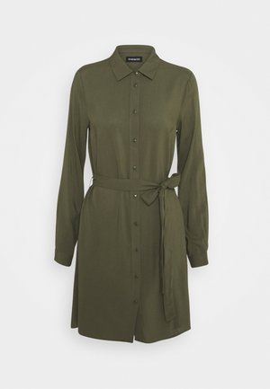 Robe-chemise à manches longues vert olive avec col pointu, boutons sur le devant et ceinture assortie en tissu nouée à la taille.