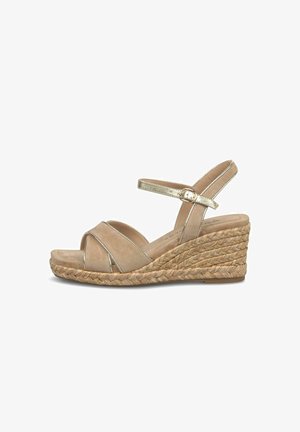 Sandale compensée beige avec semelle en jute tressé, lanières croisées à l'avant et bride de cheville dorée avec fermeture à boucle.
