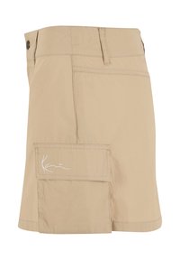 Jupe cargo beige longueur genou avec poche à rabat latérale ornée de broderies blanches en écriture et fermeture par bouton à la taille.
